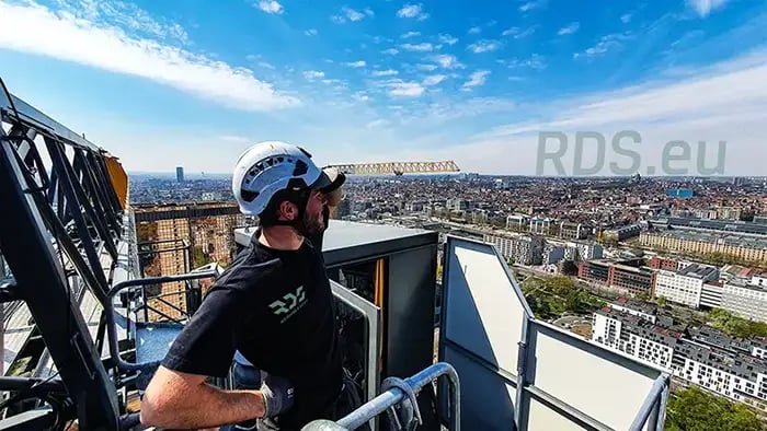 Dit is een servicetechnieker van RDS Weighing & Safety op een torenkraan aan het werk