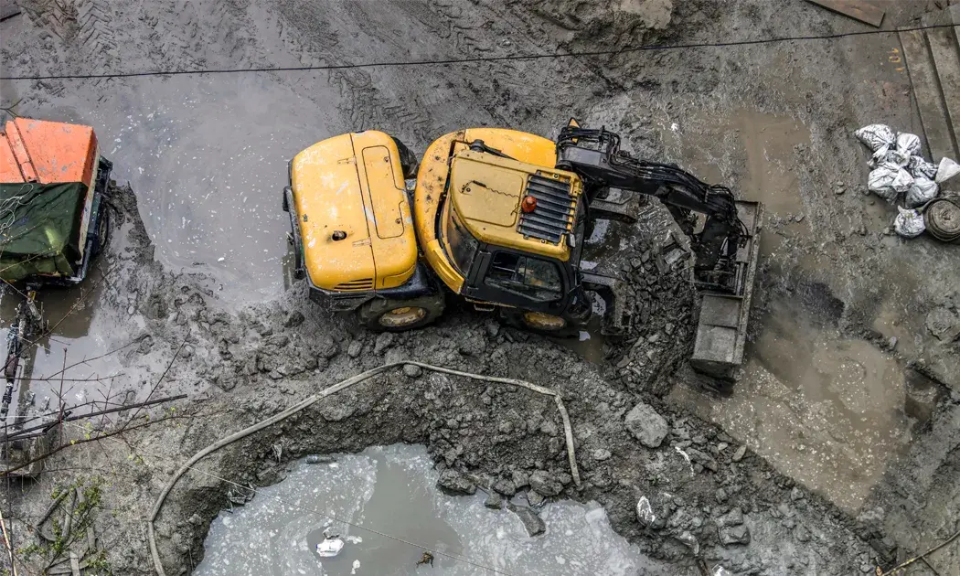 Dit is een kleine wiellader aan het werk in modderige omstandigheden - manoevreren met een achteruitrijalarm van RDS is hierbij van toepassing