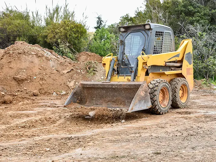 Ceci c'est un petit chargeur à roues ou chargeur compact en action