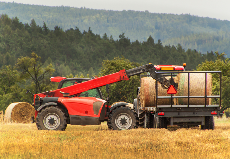 This is a telehandler placing straw bales in the agricultural sector.