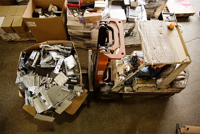 This is a forklift in the recycling sector transporting heavy materials to be weighed with a platform scale.