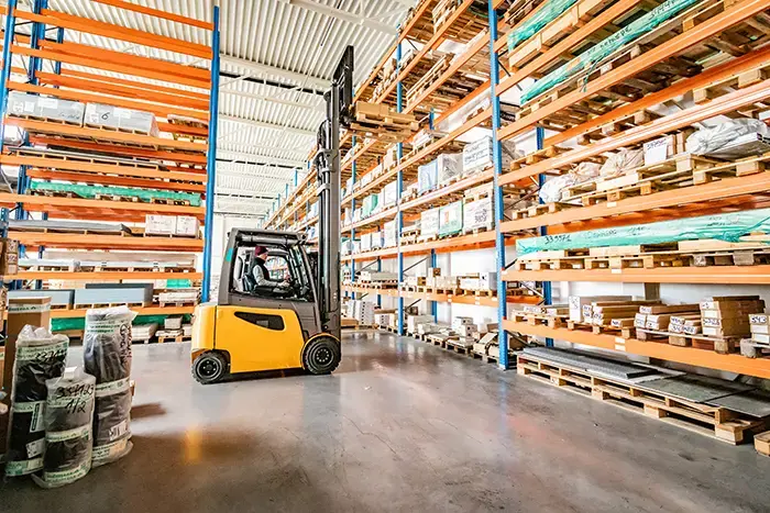 Il s'agit d'un chariot à mât rétractable qui retire une palette d'un rack.